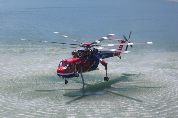 A Sikorsrky S-64 helciopter, operated by Erickson Air Crane, lands on water.