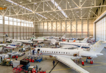 A picture of a hangar with private jets.