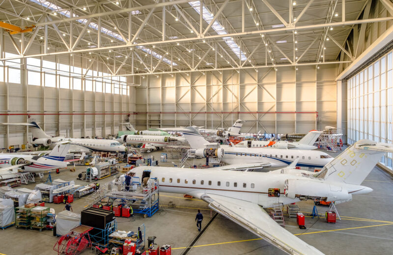 A picture of a hangar with private jets.